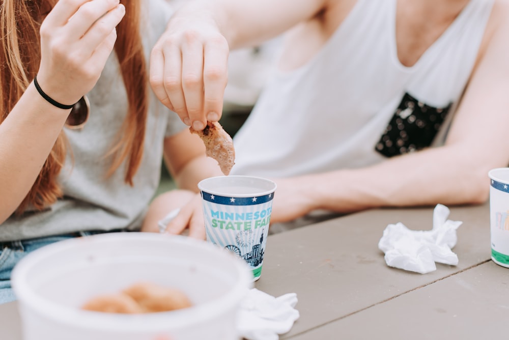 man dipping cookie on milk