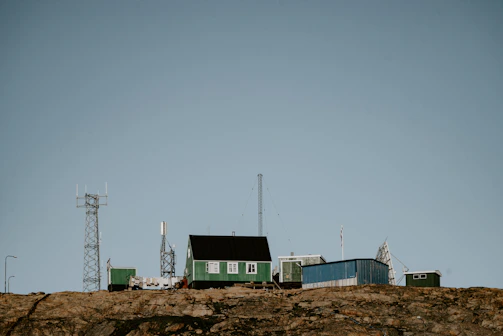 A remote desert monitoring station with solar panels and antennas under a clear blue sky