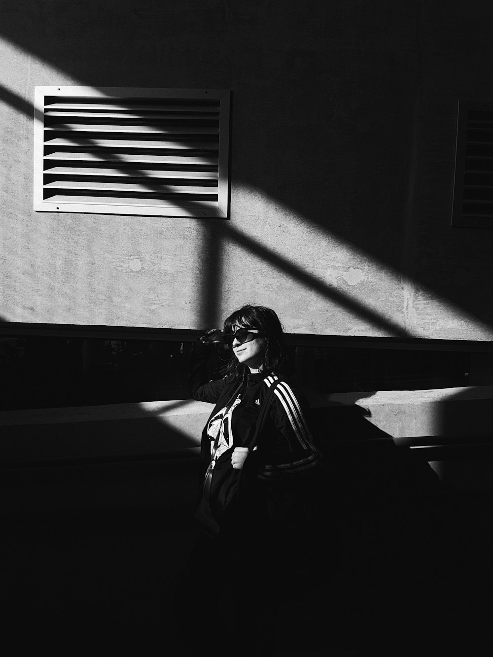 grayscale photography of woman wearing jacket and sunglasses