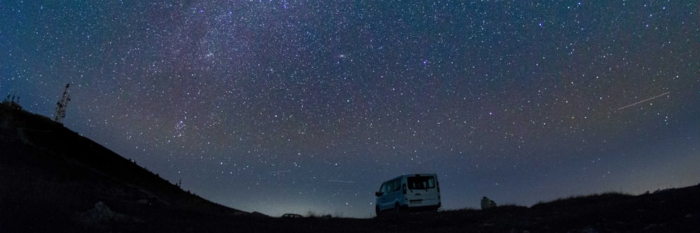 van parked on terrain under starry sky