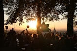 A vibrant community gathering worshipping together outdoors at sunset.