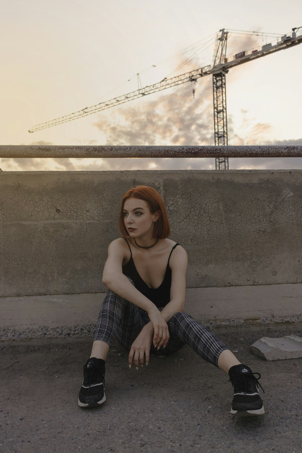 woman sitting on gray concrete railing during daytime