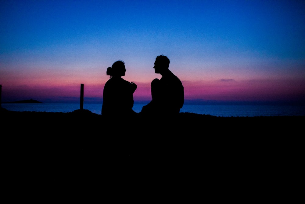 silhouette of man and woman sitting