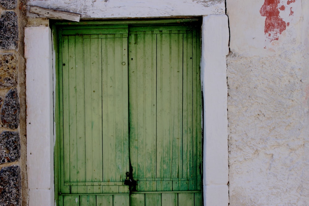 two green wooden doors both closed