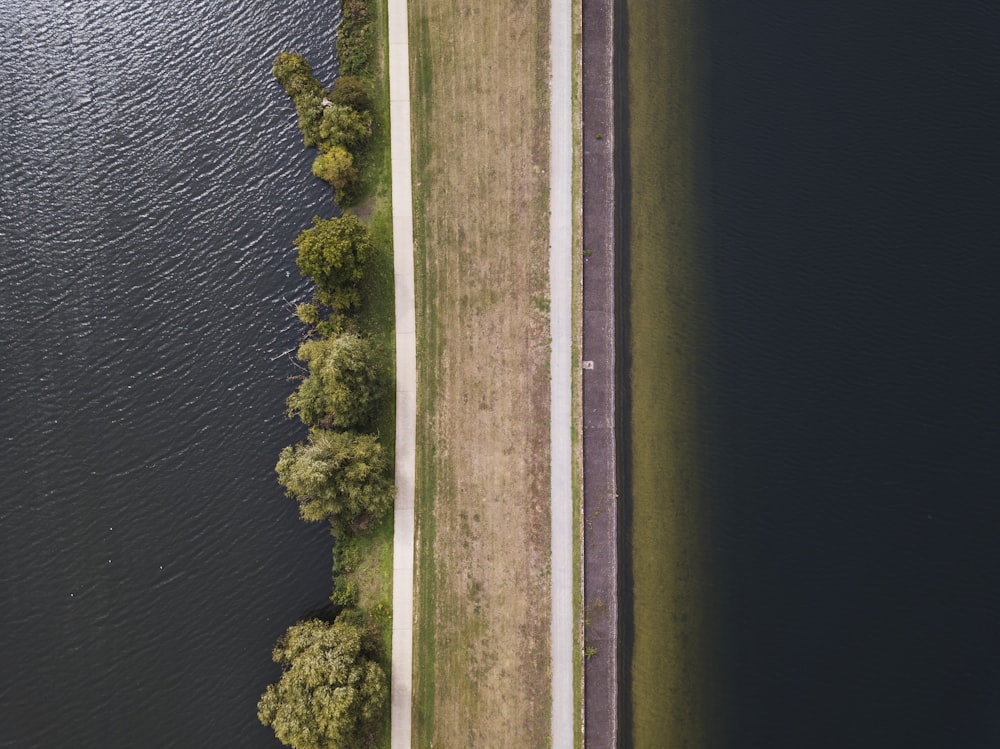aerial photography of brown road near the body of water at daytime