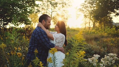 A couple embracing in a sunlit field during their prenup photo session.