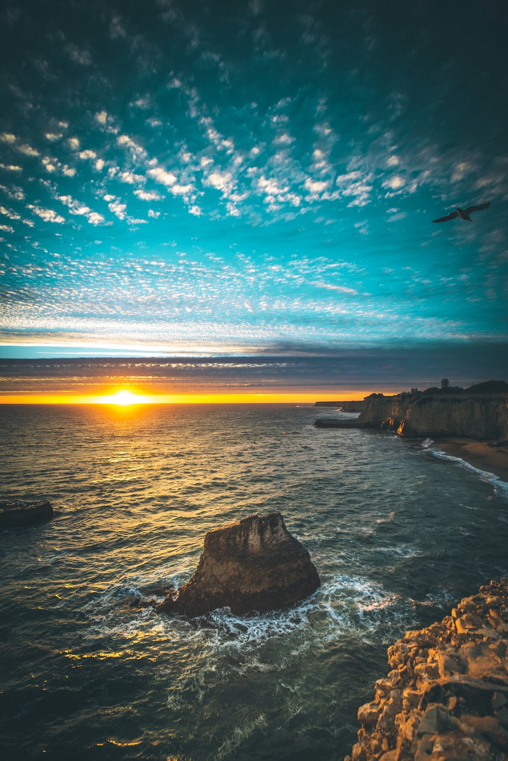 夕暮れ時の海に囲まれた岩層