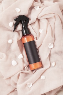 A delicate misting bottle of refreshing hair brume surrounded by soft fabric