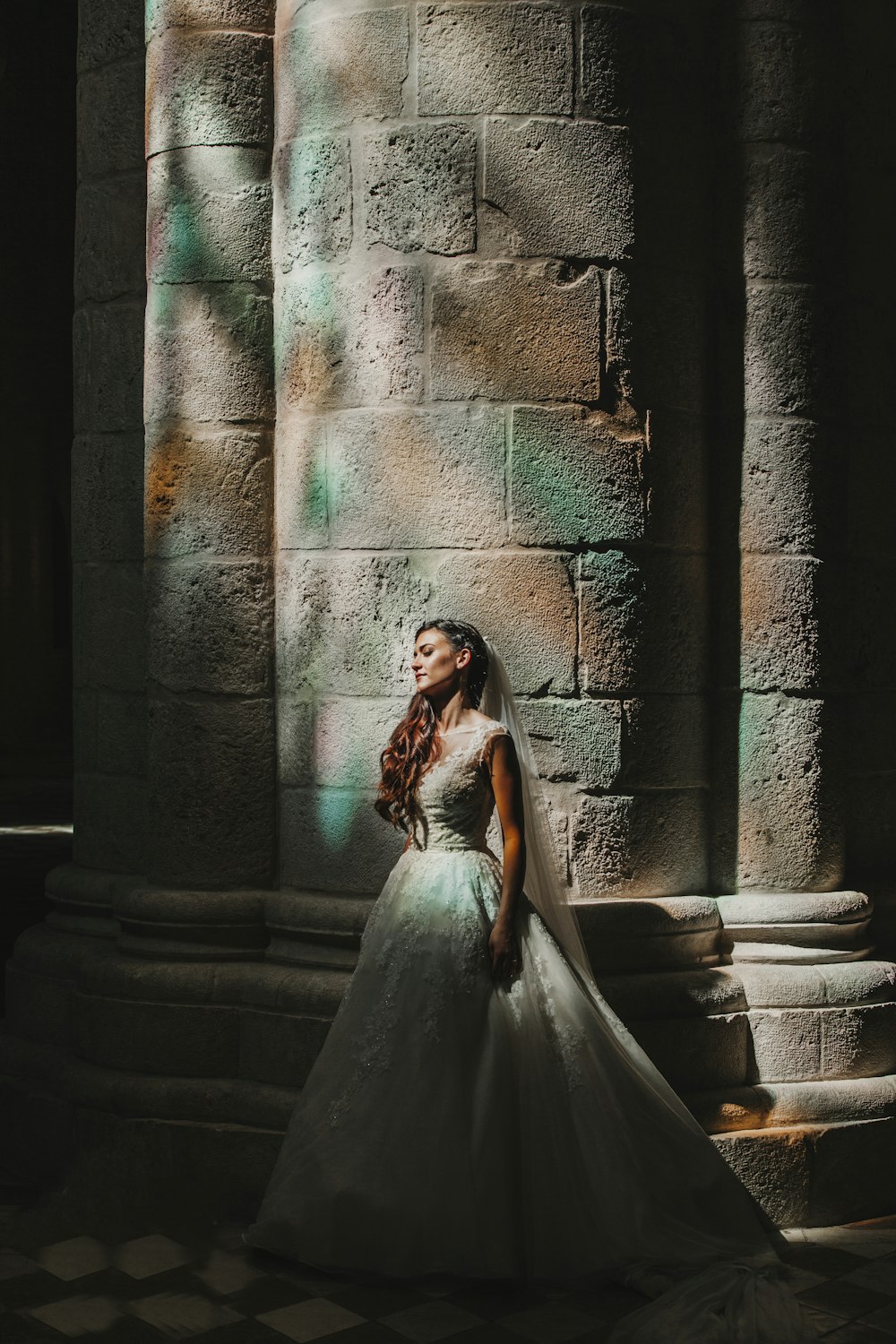 bride standing beside concrete pillar