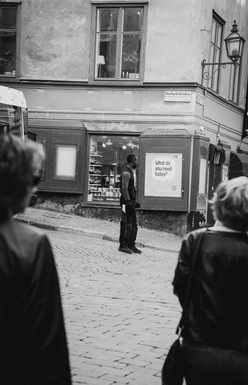 Graustufenfoto eines Mannes, der auf der Straße steht und auf Schilder schaut