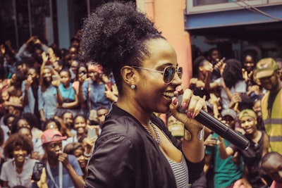 woman holding microphone near her mouth angola teams background