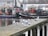 Group of anglers preparing fishing gear on a dock with boats in the background.
