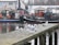 Group of anglers preparing fishing gear on a dock with boats in the background.