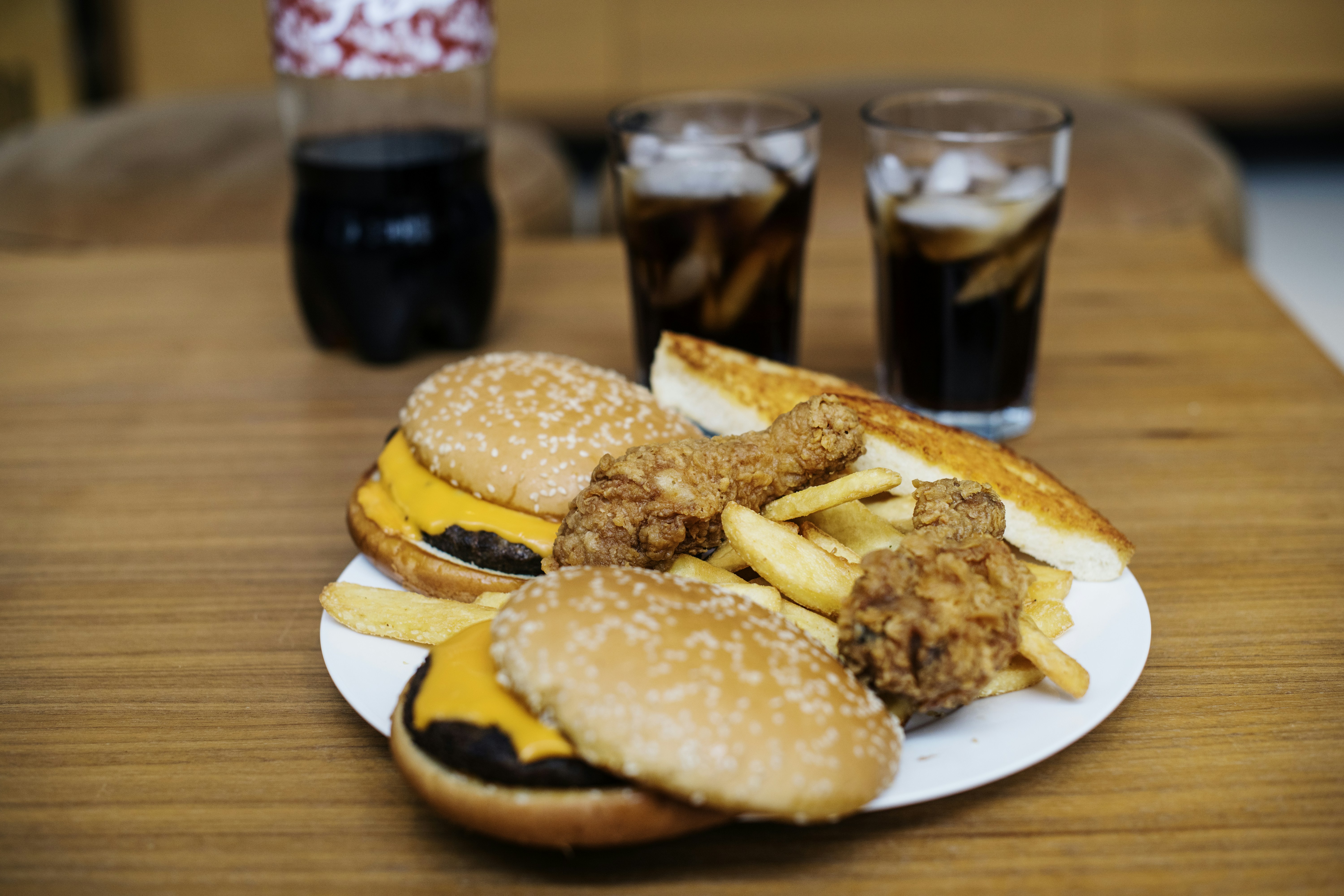 hamburger and chicken on white ceramic plate on brown wooden surface