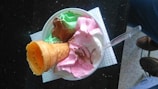 Colorful assortment of booza ice cream scoops in vibrant flavors served in a rustic bowl.
