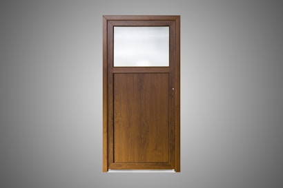 A wooden door with a simple design, featuring a large, frosted glass pane on the upper section and a solid wood panel below. The wood is of a dark brown color with a visible grain pattern. The background is a plain gray, highlighting the door.