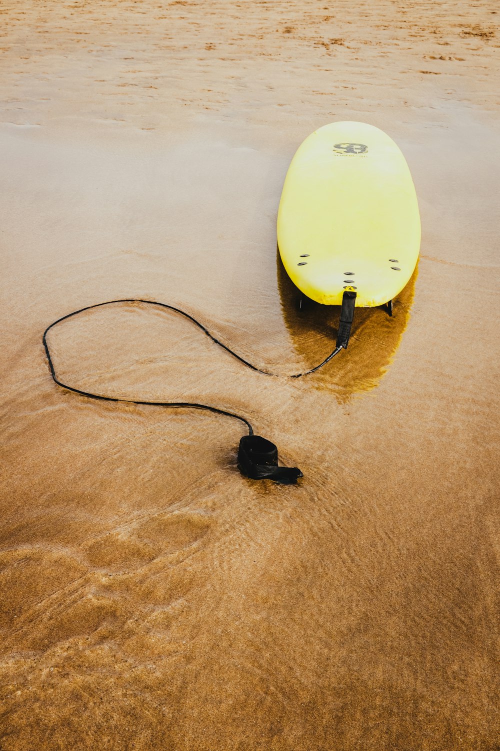 yellow bodyboard on shoreline