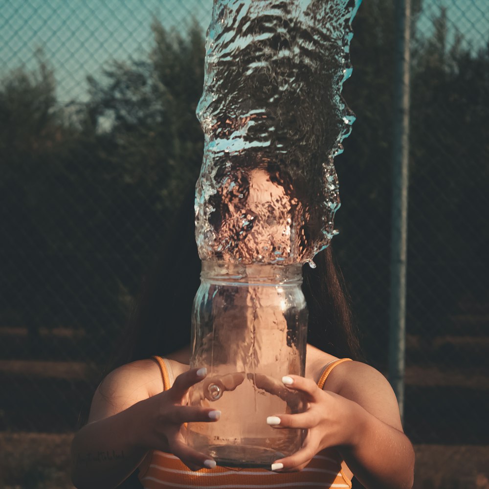 瓶から水を投げる女性
