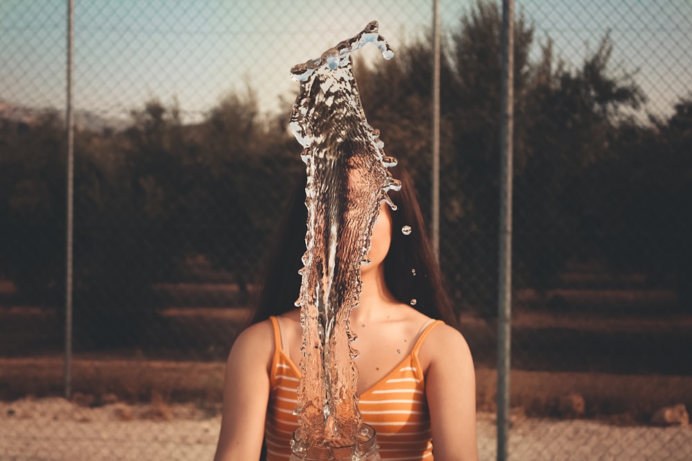 woman wearing orange and white striped spaghetti strap top