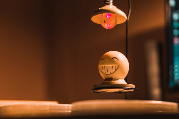 A smiling customer holding a custom 3D printed figurine in warm lighting.