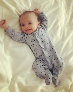 A happy baby wearing a stylish onesie in a playful setting.