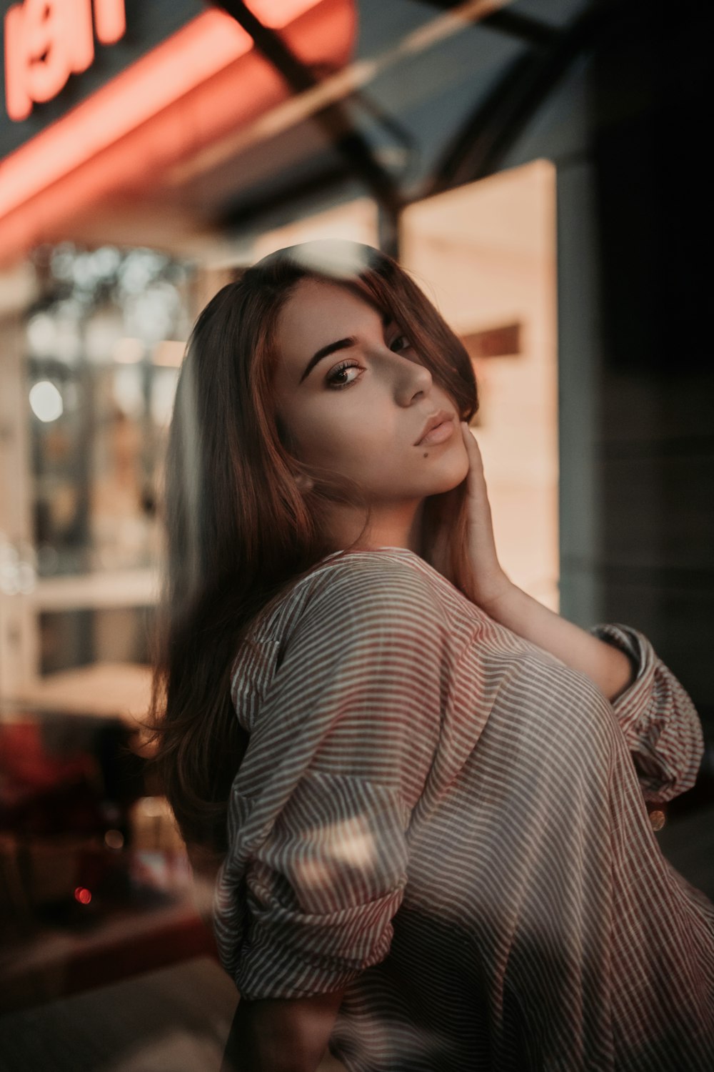 woman holding her neck pose inside building