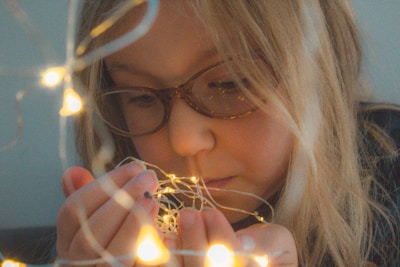Close-up of a child experimenting with lenses and light beams.