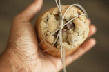 A smiling child holding a gooey chocolate chip cookie with a bite taken out
