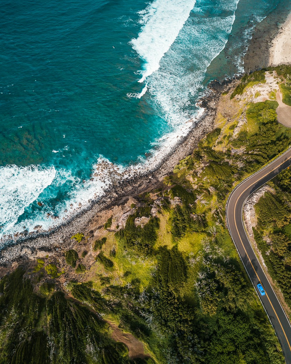 aerial photography of road on mountain near shore