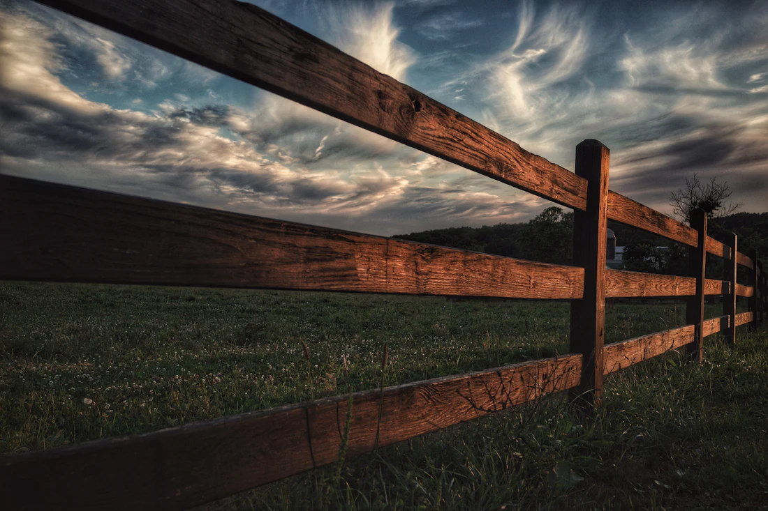 Wooden fence and gate beside a grass field