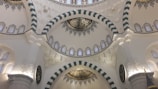 A peaceful mosque interior with intricate Islamic geometric patterns and calligraphy.