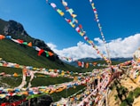 Colorful prayer flags fluttering against a bright blue sky in Sikkim's mountain landscape