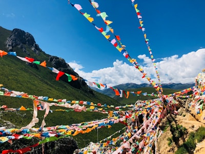 Colorful prayer flags fluttering against a bright blue sky in Sikkim's mountain landscape