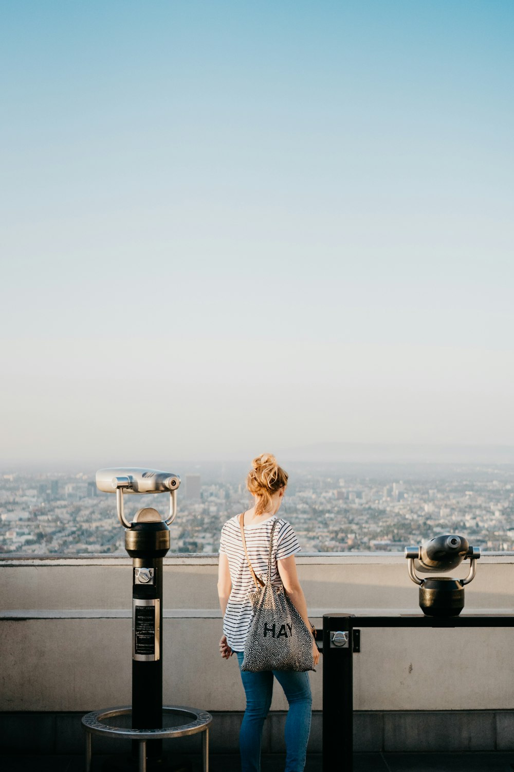 woman standing beside telescope during daytime