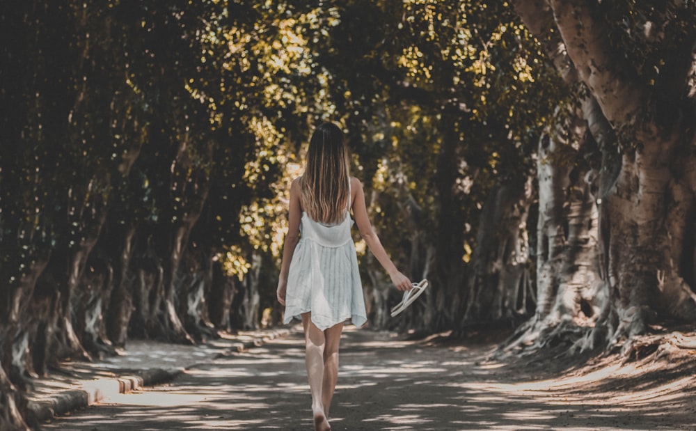 woman walking under trees