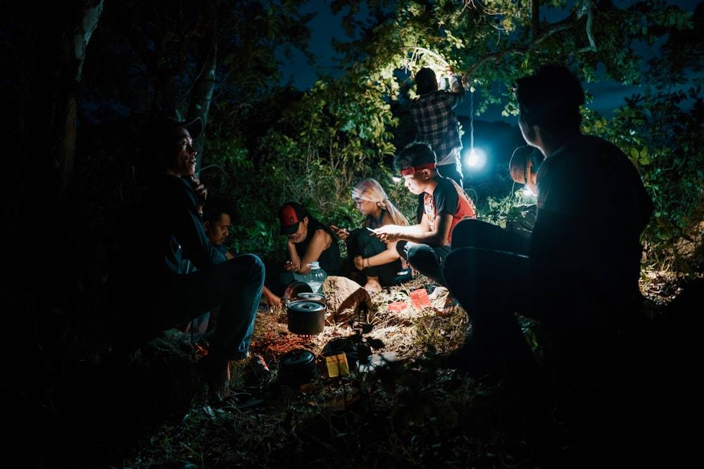 campers gathering in forest during nighttime