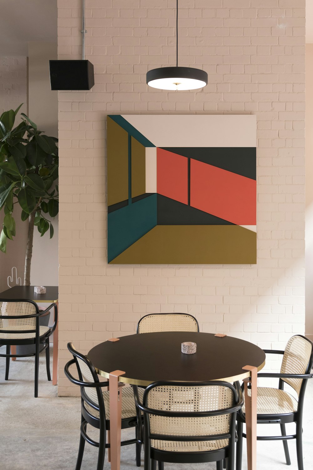 round brown wooden table and four white chairs