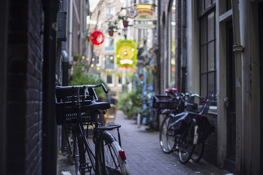 selective focus photo of leaning bike in between buildings at daytime