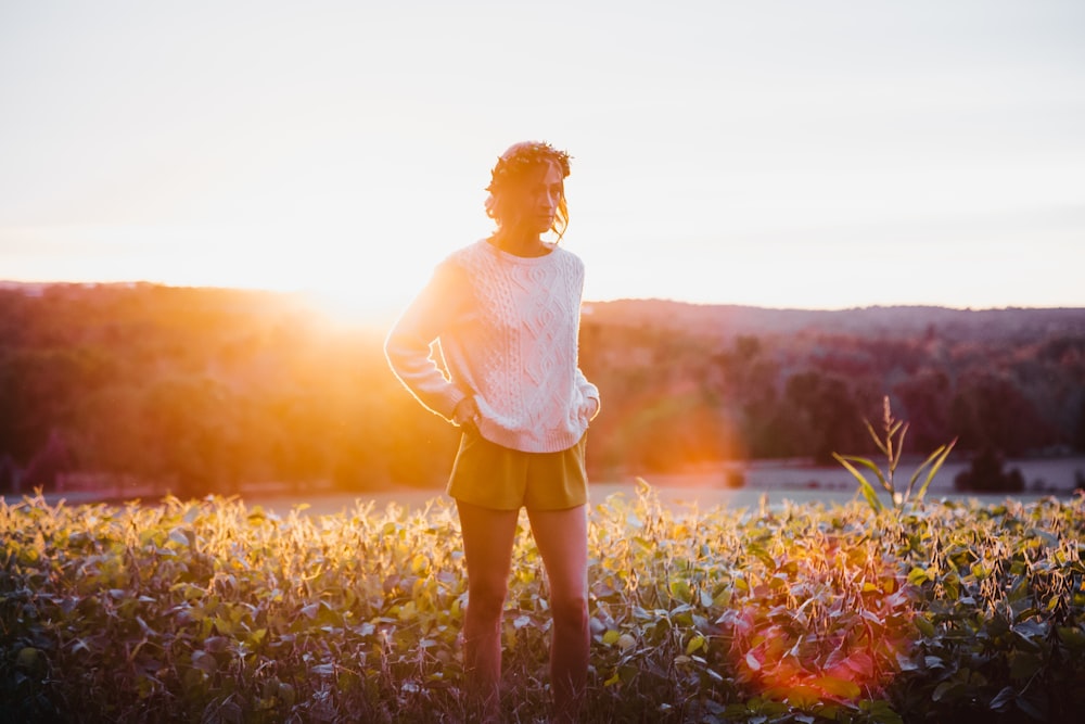 woman standing near green grass during golden hour