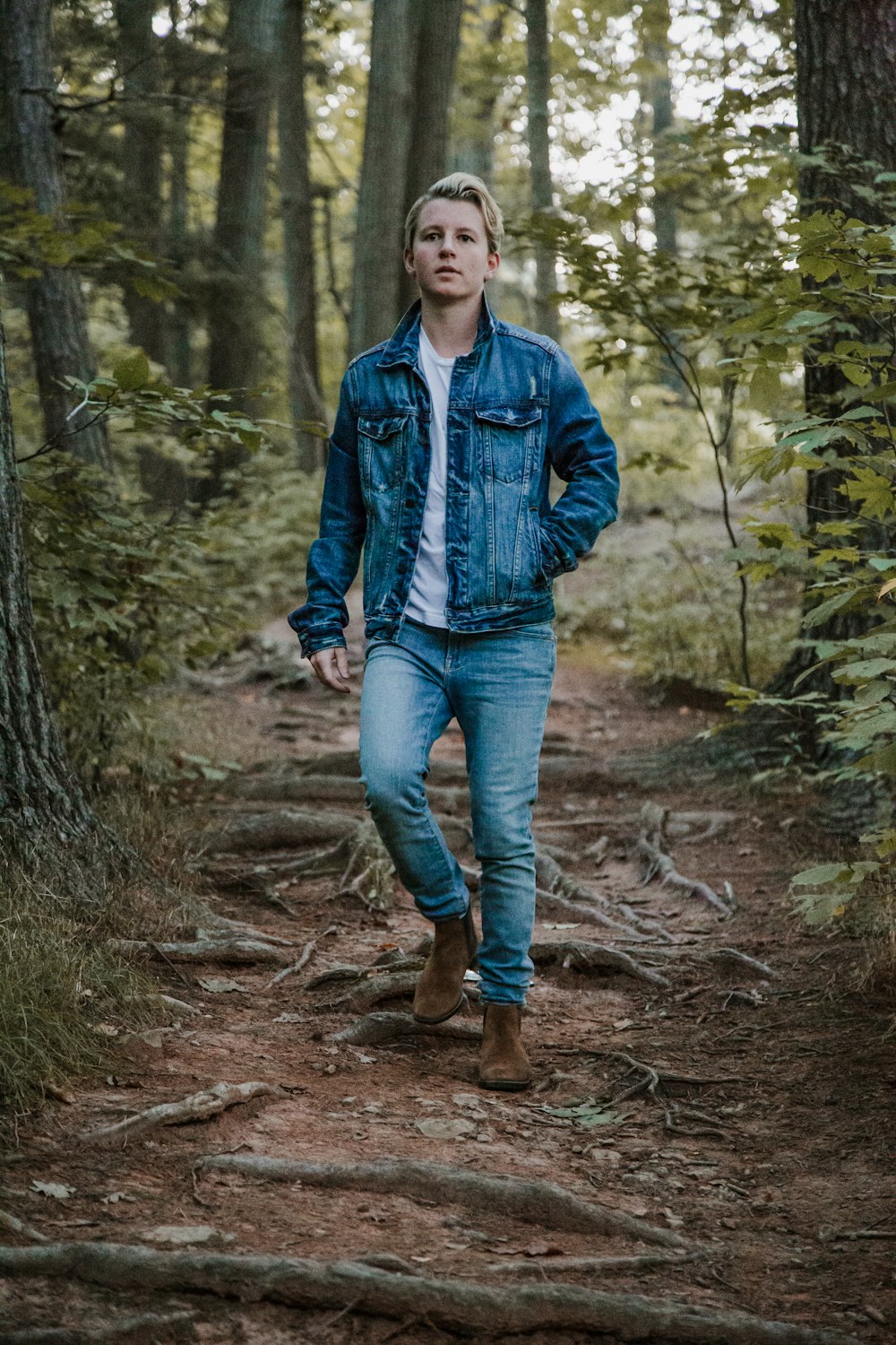 men's blue denim button-up jacket between trees