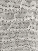 Bridal lace fabric with delicate scalloped edges and floral details.