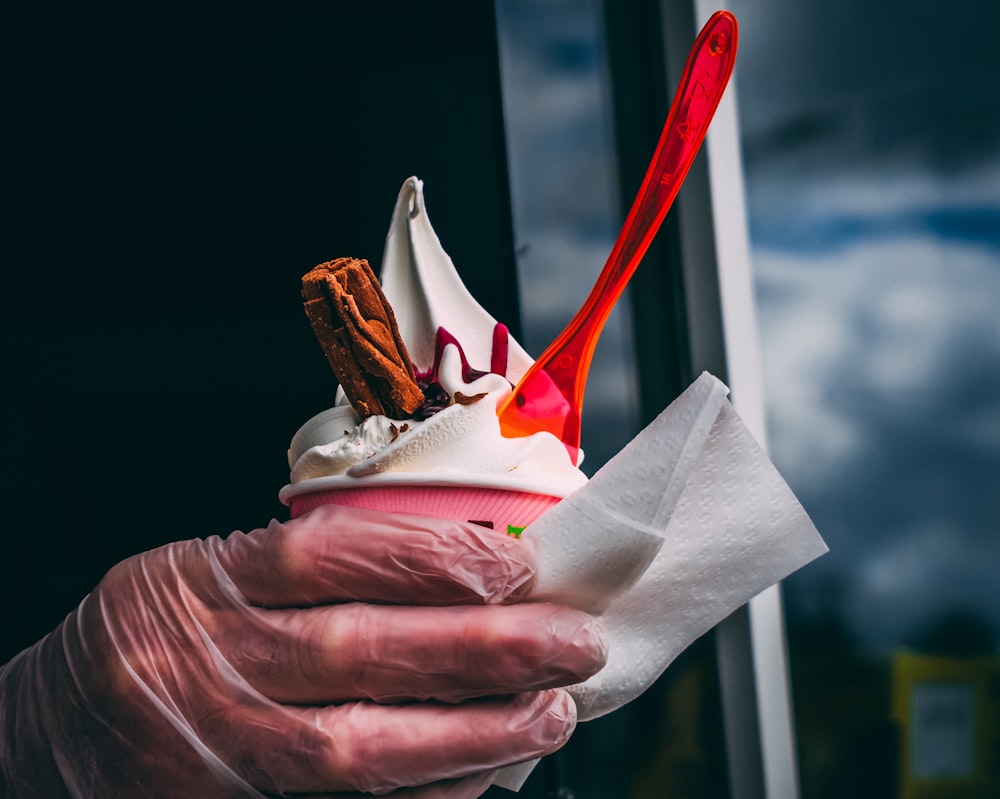 woman holding cup of vanilla ice cream