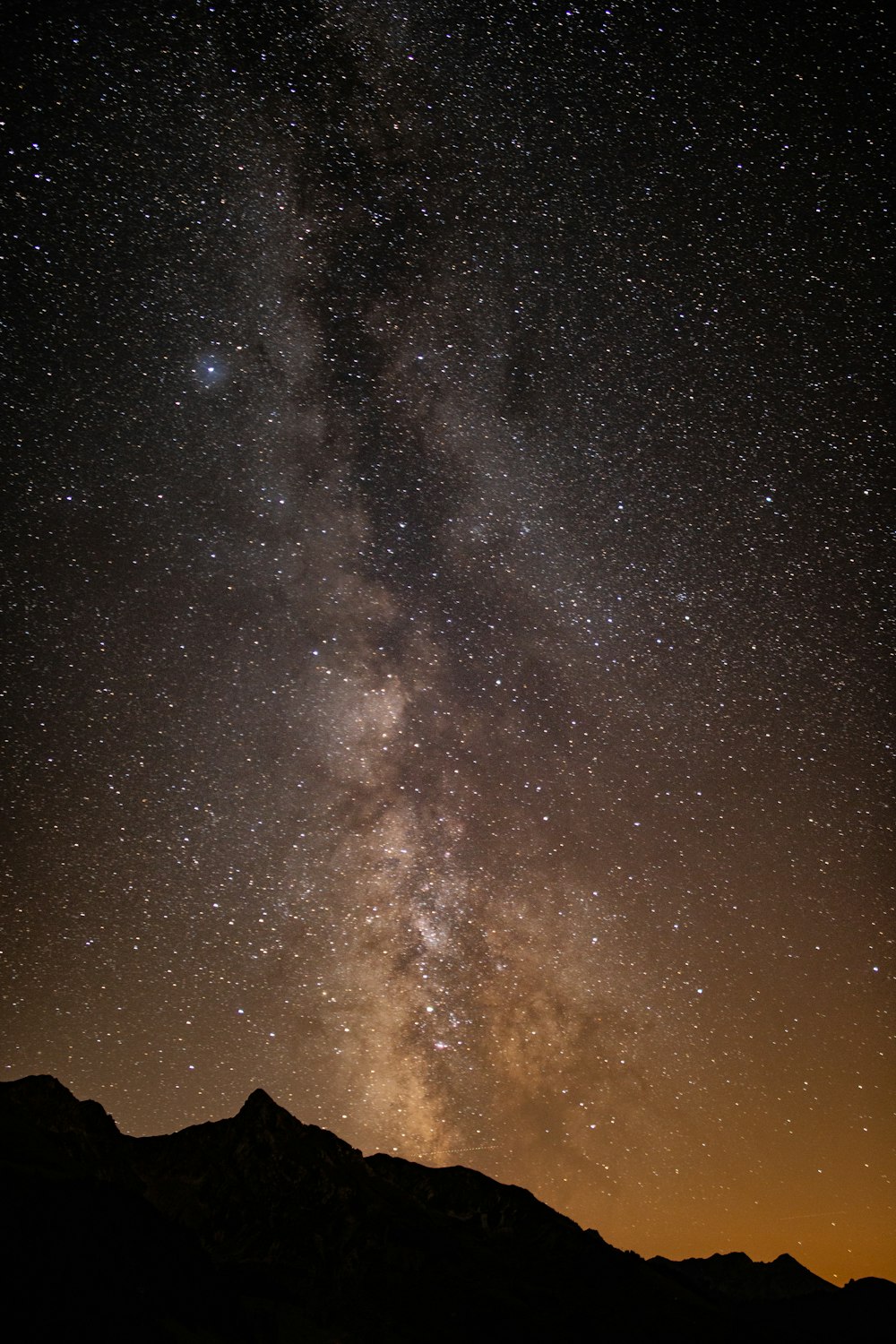 silhouette of mountain and stars during night time
