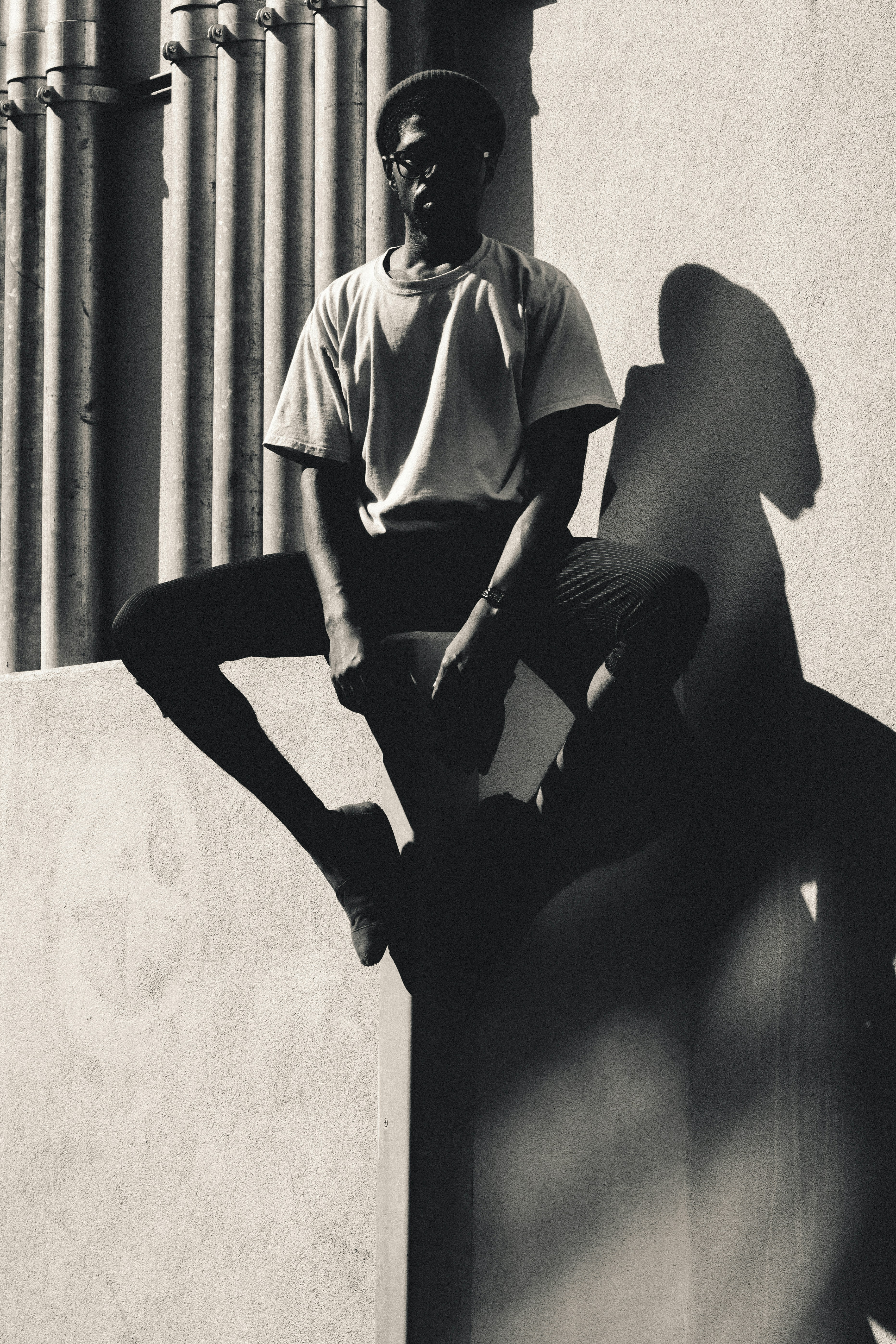 콘크리트 포장 도로에 앉아 있는 사람의 회색조 사진