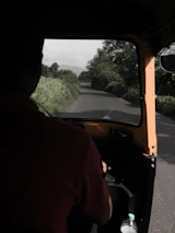 An Ertiga vehicle cruising smoothly on a highway with scenic greenery.