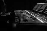 A close-up of a music producer working on a mixing console.