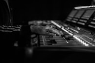 Close-up of a sound engineer adjusting levels on a mixing console.