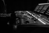 A close-up of hands mixing sound on a professional audio console.