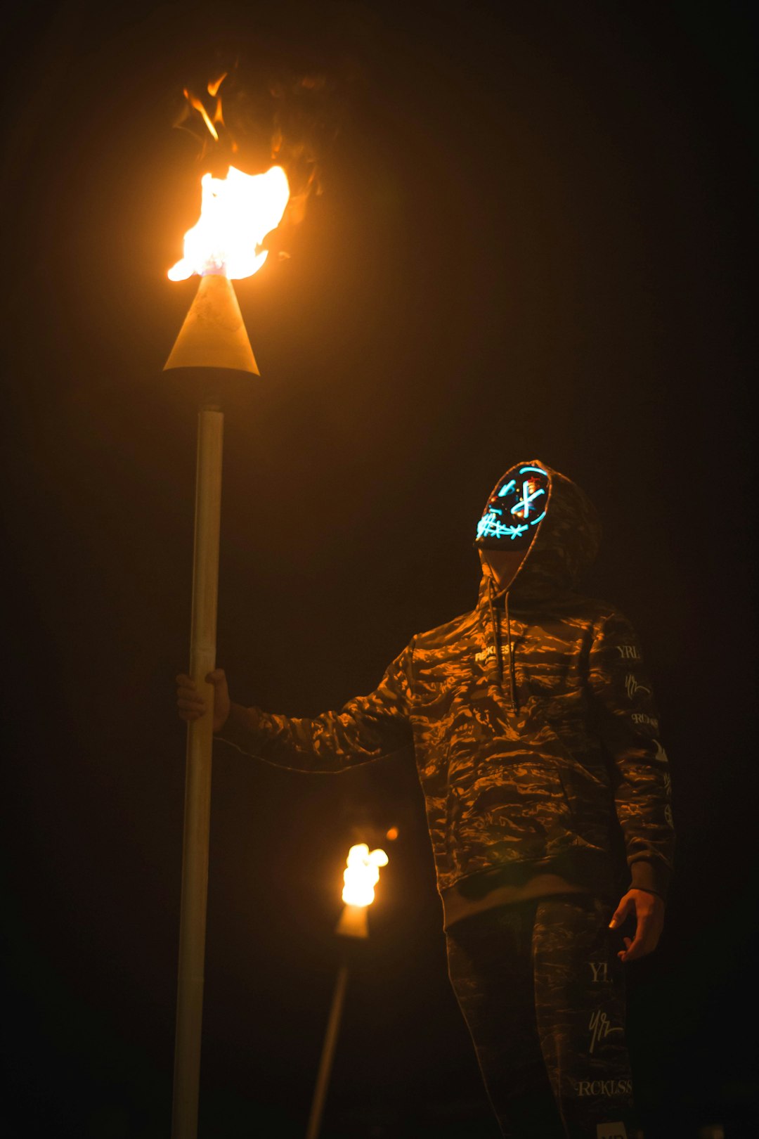 person holding torch while walking at night