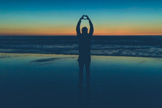silhouette of person making heart sign near seashore in Ocean Beach United States
